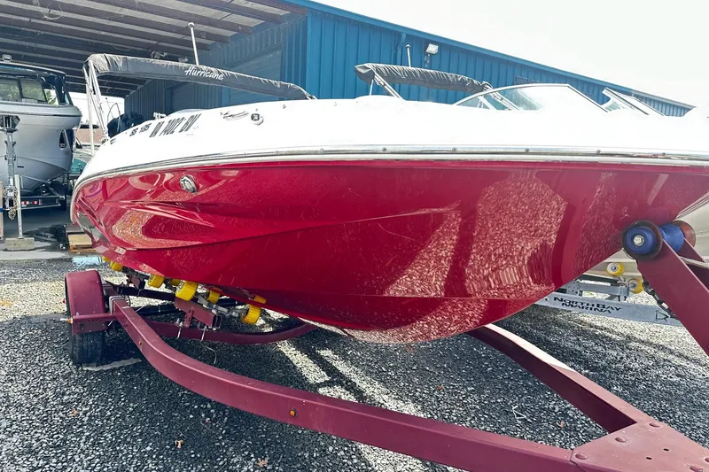 The Image of 2022 Godfrey Hurricane 185 SD boat with red hull on trailer in storage facility. - 0