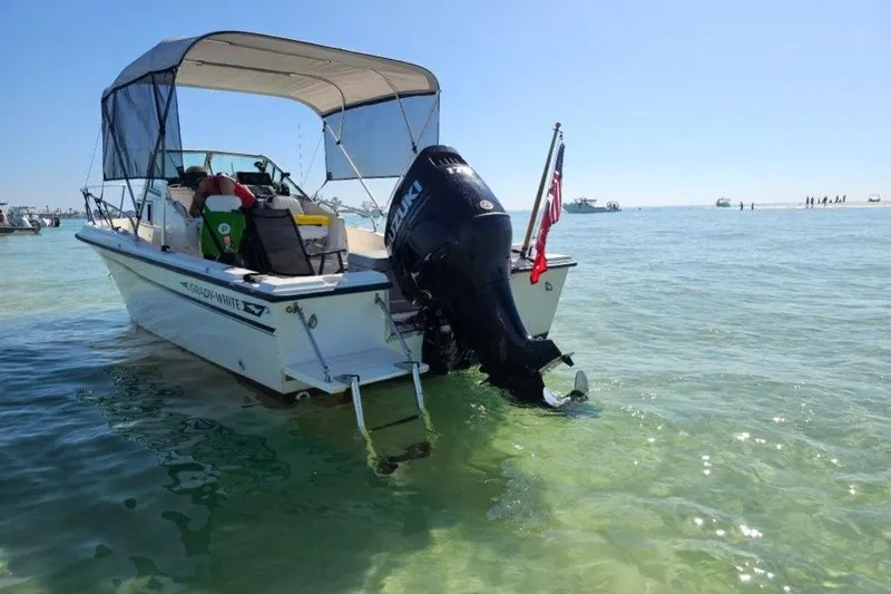 Slide: The Image of 1989 Grady-White Overnighter 204 boat with canopy in clear, shallow water. - 3