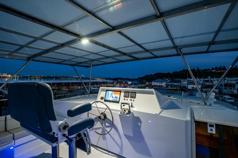 Slide: The Image of Helm of 2009 Northwest Powercats 58 yacht at dusk, featuring modern controls and seating. - 27