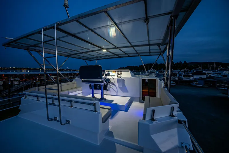Slide: The Image of Luxurious 2009 Northwest Powercats 58 yacht deck illuminated at night, featuring modern seating and helm. - 28