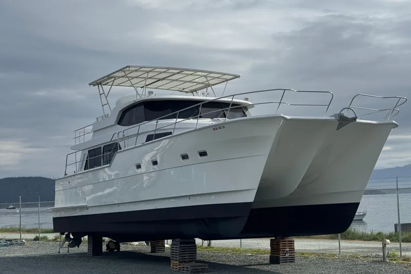 Slide: The Image of 2009 Northwest Powercats 58 catamaran on land, with overcast sky background. - 44