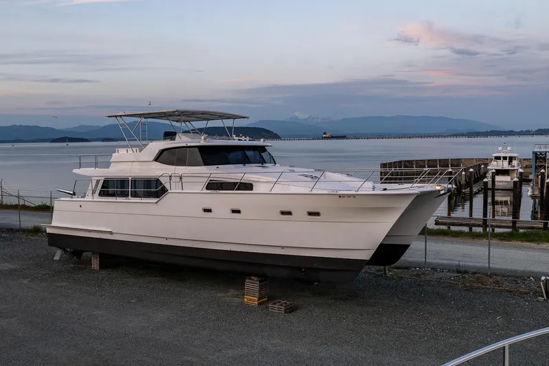 Slide: The Image of 2009 Northwest Powercats 58 yacht on land near a serene waterfront. - 45