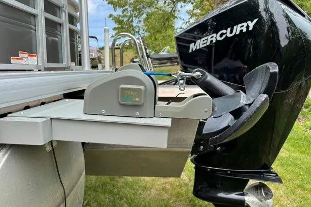 Slide: The Image of 2024 Sun Tracker Party Barge 22 RF XP3 with Mercury outboard motor, docked on grass. - 14