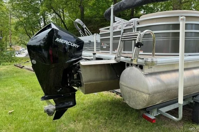 Slide: The Image of 2024 Sun Tracker Party Barge 22 RF XP3 with Mercury outboard motor, parked on grass. - 5