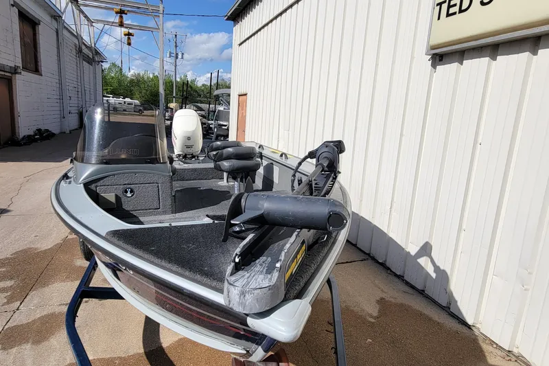 Slide: The Image of 2005 Lund Mr. Pike 16 fishing boat on a stand, outdoors near a building. - 11