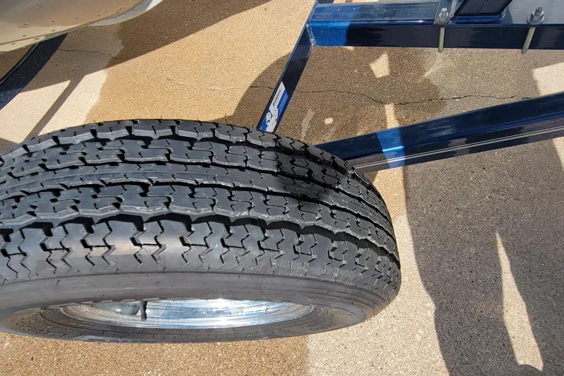 Slide: The Image of Trailer tire of a 2005 Lund Mr. Pike 16 boat on concrete surface. - 13