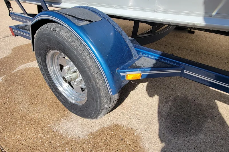 Slide: The Image of Trailer wheel of a 2005 Lund Mr. Pike 16 boat on a sunny day. - 15