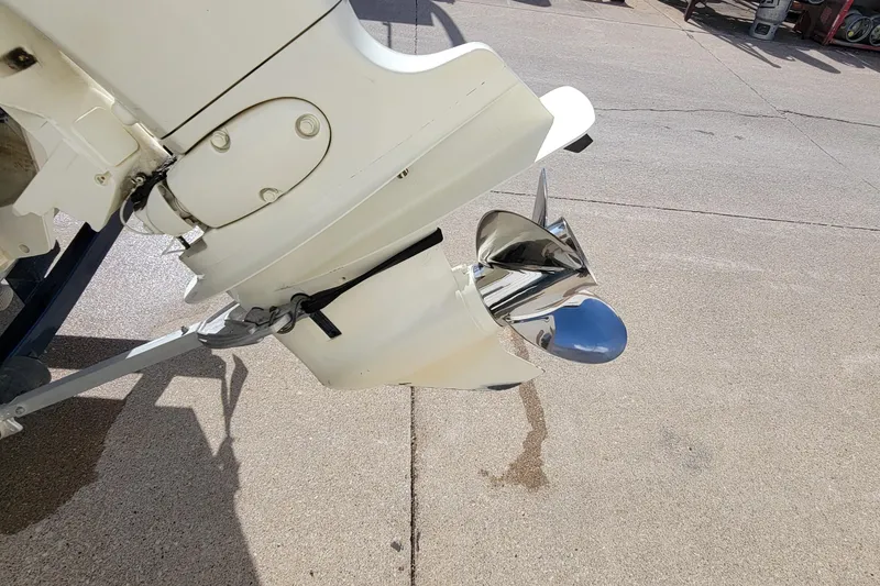 Slide: The Image of 2005 Lund Mr. Pike 16 boat motor with shiny propeller on concrete surface. - 18