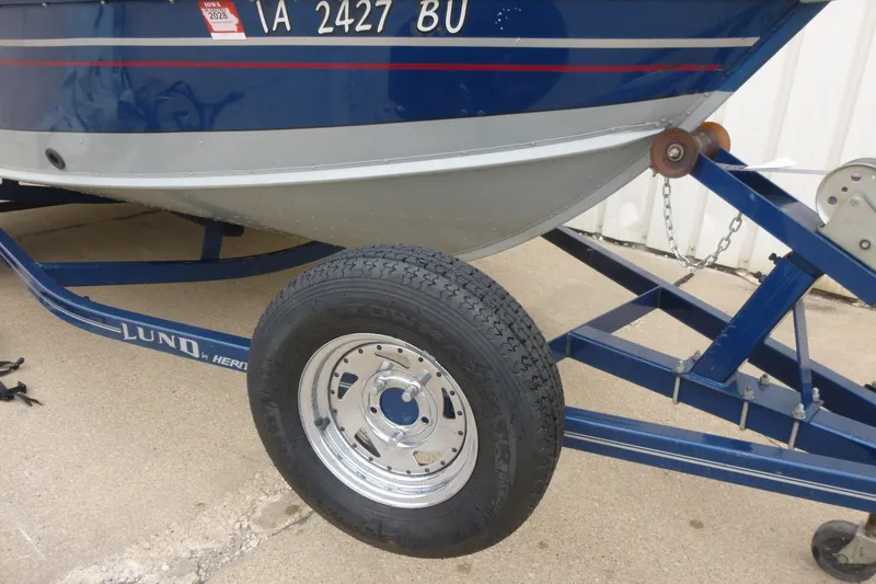Slide: The Image of 2005 Lund Mr. Pike 16 boat on trailer, featuring blue and silver design. - 4