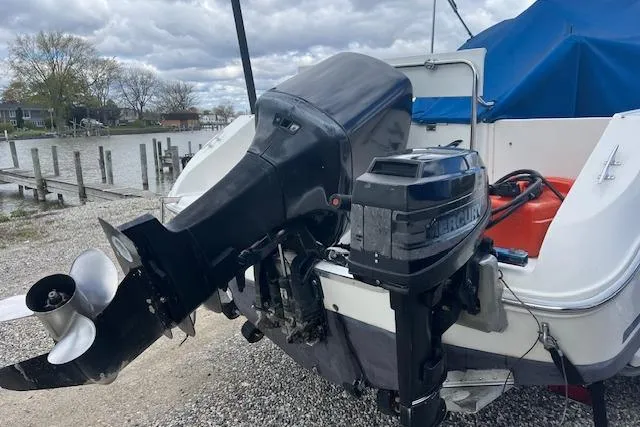 Slide: The Image of 1996 Sea Ray Laguna 24 Flushdeck Cuddy with Mercury outboard motor, docked by a lakeside. - 3