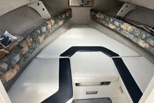 Slide: The Image of 1996 Sea Ray Laguna 24 Flushdeck Cuddy interior with cushioned seating and storage. - 8