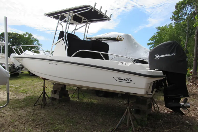 Slide: The Image of 2014 Boston Whaler 210 Dauntless boat on stands, with Mercury engine cover. - 1