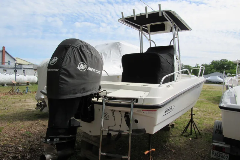 Slide: The Image of 2014 Boston Whaler 210 Dauntless boat with Mercury engine covers, parked outdoors. - 2