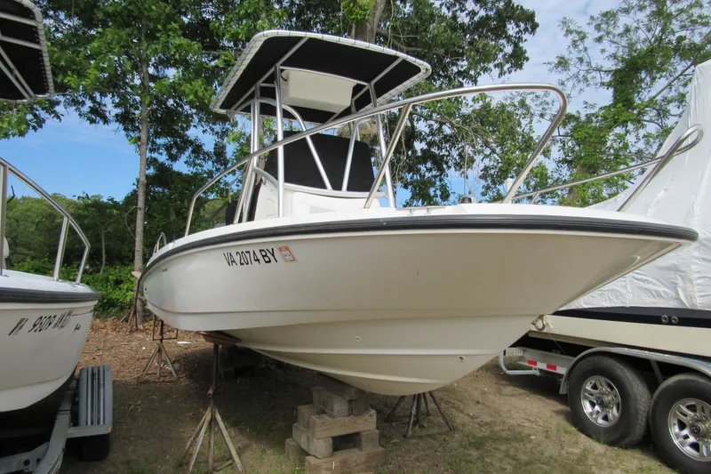 Slide: The Image of 2014 Boston Whaler 210 Dauntless boat on stands, surrounded by trees. - 3