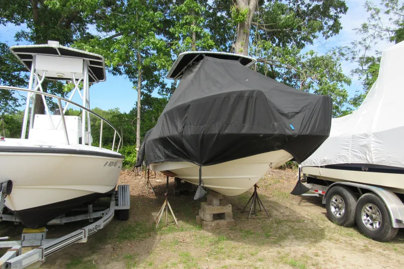 Slide: The Image of 2014 Boston Whaler 210 Dauntless boat covered, stored outdoors with other boats. - 6
