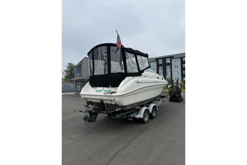 Slide: The Image of 1997 Sea Ray 240 Sundancer boat on trailer, parked outdoors with protective cover. - 2