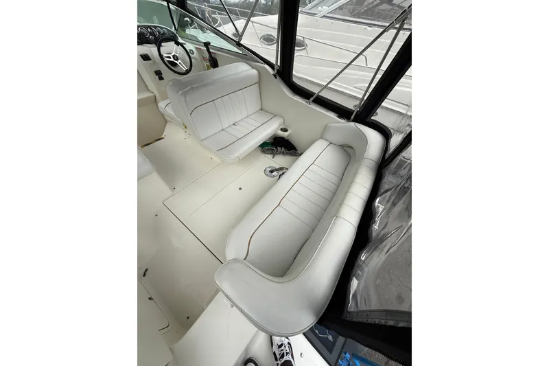 Slide: The Image of 1997 Sea Ray 240 Sundancer interior with white seating and steering wheel. - 6