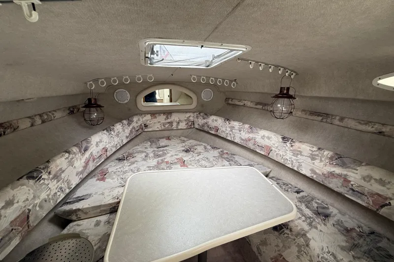 Slide: The Image of Interior cabin of a 1997 Sea Ray 240 Sundancer with patterned seating and table. - 7