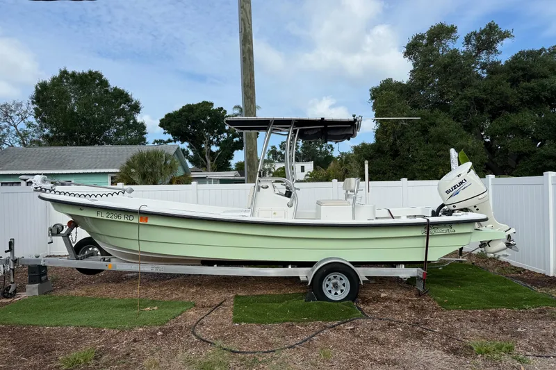 The Image of 2016 Panga 22 Boca Grande boat on trailer, parked outdoors with trees and fence background. - 0