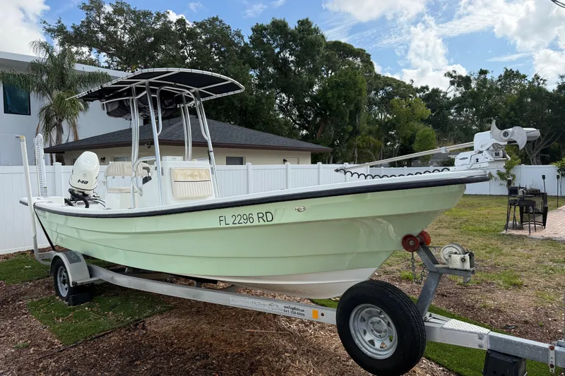 Slide: The Image of 2016 Panga 22 Boca Grande boat on trailer, parked outdoors near a house. - 2