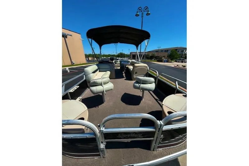 Slide: The Image of 2011 Sun Tracker Fishin' Barge 24 DLX pontoon boat with seating and canopy in a parking lot. - 5