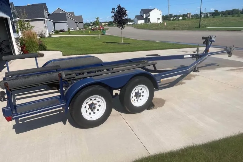 Slide: The Image of Boat trailer for 2002 Four Winns 240 Horizon on a suburban driveway. - 3