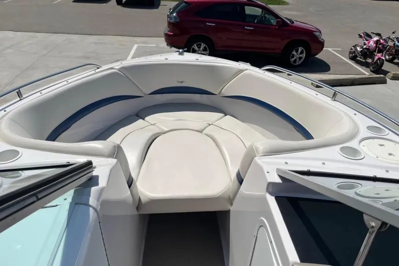 Slide: The Image of 2002 Four Winns 240 Horizon boat with spacious bow seating in a parking lot. - 8