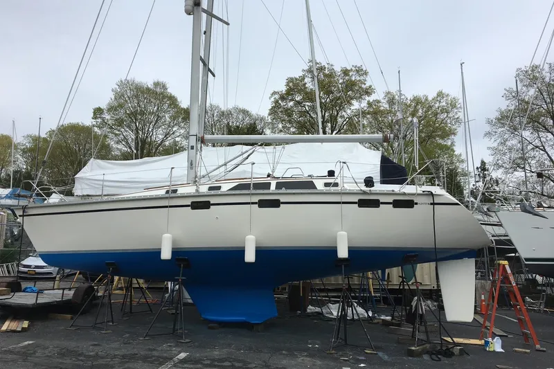 The Image of 1991 Hunter Legend 375 sailboat on stands, ready for maintenance in a boatyard. - 0
