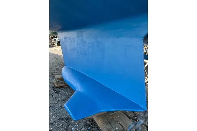 Slide: The Image of Blue hull of 1991 Hunter Legend 375 sailboat on dry dock. - 4