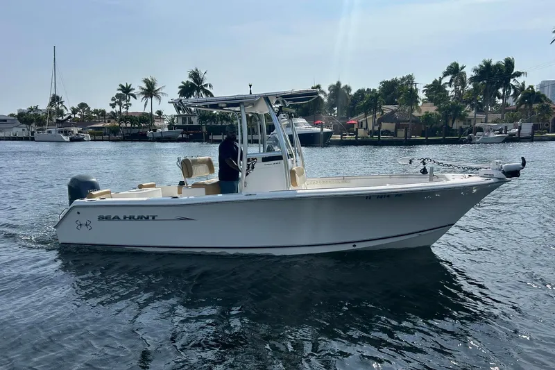 The Image of 2013 Sea Hunt Triton 225 boat cruising on a sunny day with palm trees in the background. - 0
