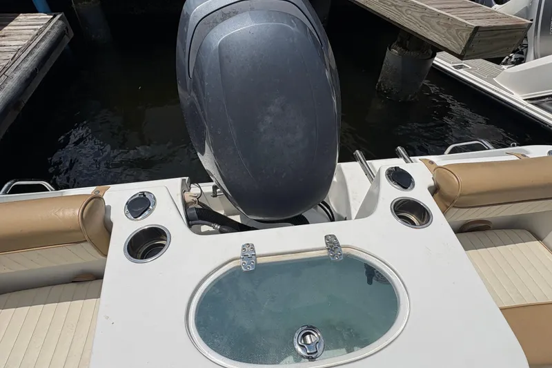 Slide: The Image of 2013 Seahunt Triton 225 boat with T-top and rod holders, docked under a partly cloudy sky. - 17