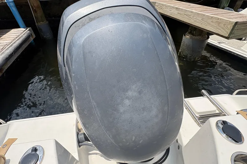 Slide: The Image of 2013 Seahunt Triton 225 boat dashboard with steering wheel and gauges, docked near waterfront homes. - 18