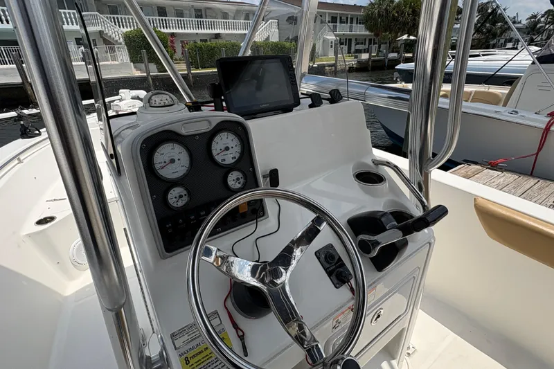 Slide: The Image of 2013 Seahunt Triton 225 boat docked at marina with palm trees and blue sky. - 22
