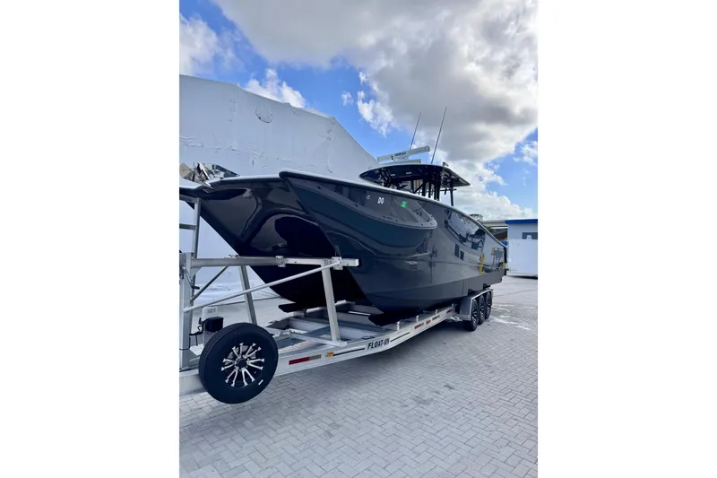 Slide: The Image of Black 2019 Freeman 34VH boat on trailer under cloudy sky. - 11