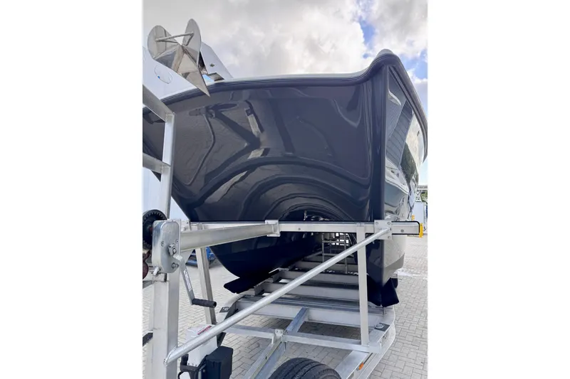 Slide: The Image of 2019 Freeman 34VH boat on trailer, showcasing sleek hull design under cloudy sky. - 12