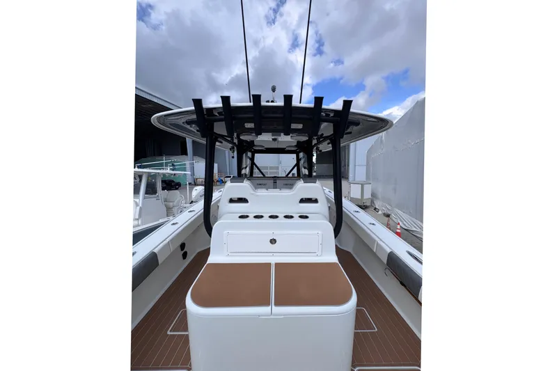 Slide: The Image of 2019 Freeman 34VH boat interior with seating and rod holders under a cloudy sky. - 7