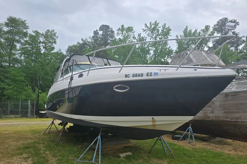 Slide: The Image of 2003 Rinker Fiesta Vee 342 boat on stands, surrounded by trees. - 10