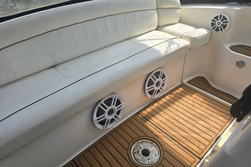 Slide: The Image of 2003 Rinker Fiesta Vee 342 boat interior with white seating and wood flooring. - 16