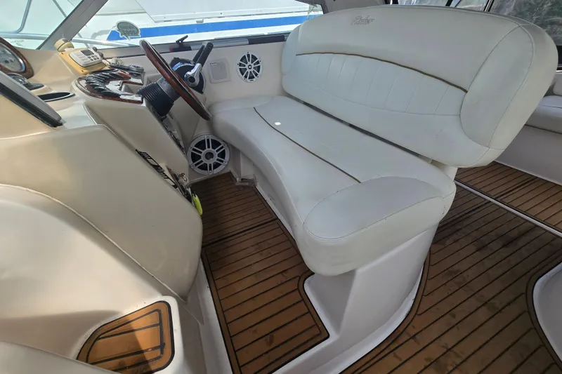Slide: The Image of 2003 Rinker Fiesta Vee 342 boat interior with white seating and wooden flooring. - 19