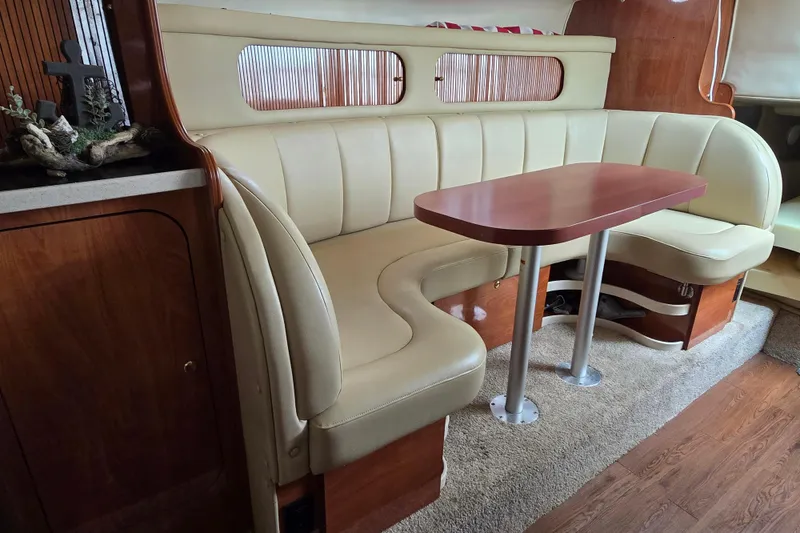 Slide: The Image of 2003 Rinker Fiesta Vee 342 interior with beige seating and wooden table. - 23