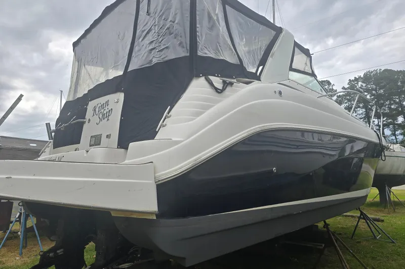 Slide: The Image of 2003 Rinker Fiesta Vee 342 boat on land, covered, with overcast sky. - 31