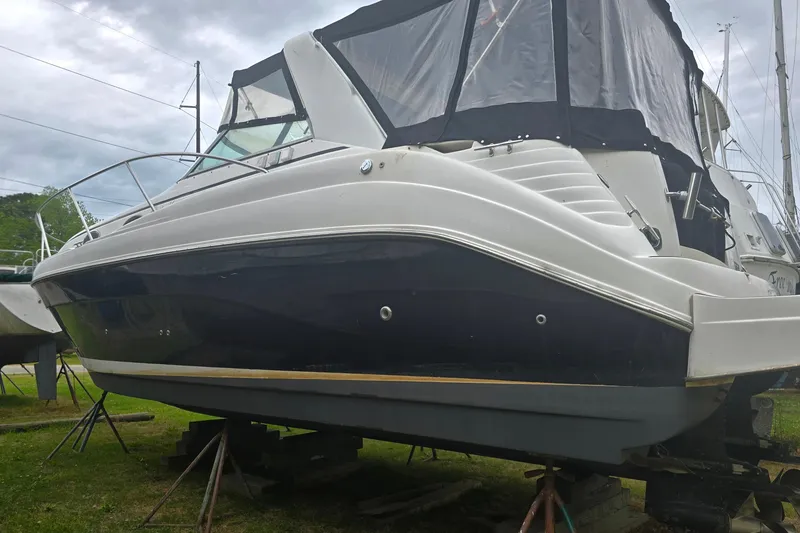 Slide: The Image of 2003 Rinker Fiesta Vee 342 boat on stands, featuring a sleek design and covered cockpit. - 32