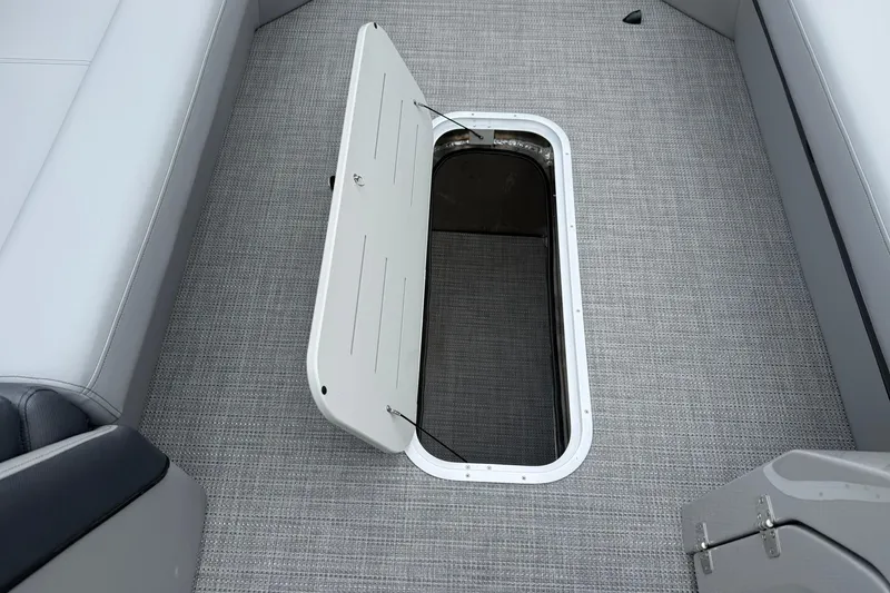 Slide: The Image of Open storage compartment on 2026 Bentley Pontoons Elite 253 Swingback boat with gray flooring. - 4
