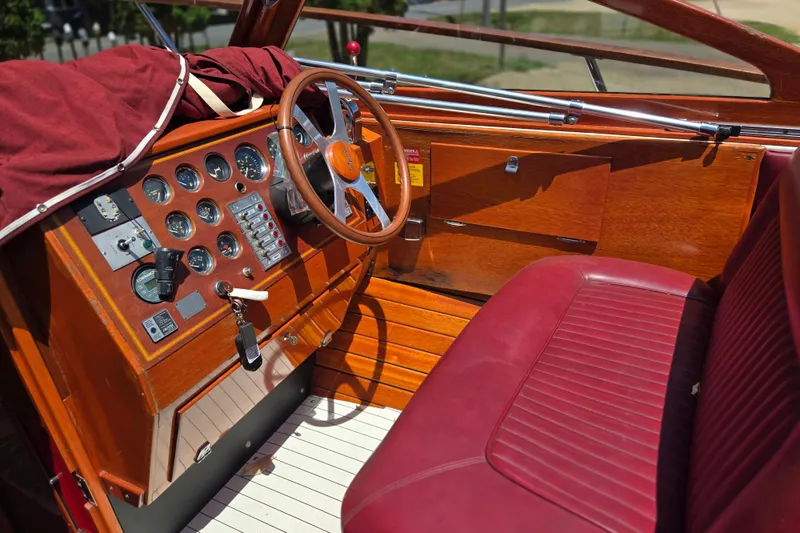 Slide: The Image of Interior of a 1990 Windsor Craft Cuddy boat with wooden dashboard and red leather seating. - 12