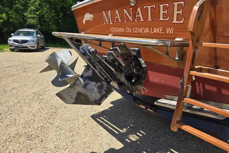 Slide: The Image of 1990 Windsor Craft Cuddy boat with "Manatee" lettering, parked near a car. - 14