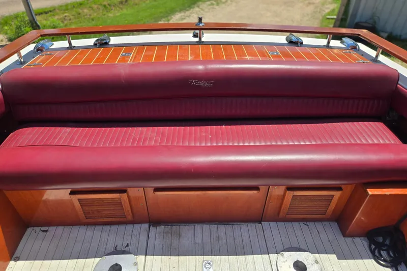 Slide: The Image of Red leather seating on a 1990 Windsor Craft Cuddy boat with wooden accents. - 22