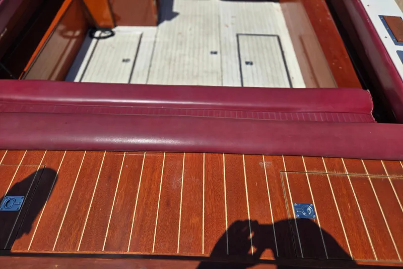 Slide: The Image of Interior of 1990 Windsor Craft Cuddy boat with wooden and maroon leather details. - 23