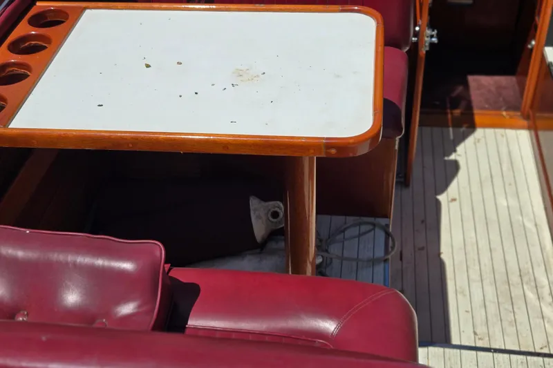 Slide: The Image of Interior of a 1990 Windsor Craft Cuddy boat with red seating and a wooden table. - 26