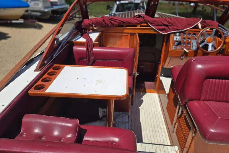 Slide: The Image of 1990 Windsor Craft Cuddy boat interior with burgundy seating and wooden accents. - 27