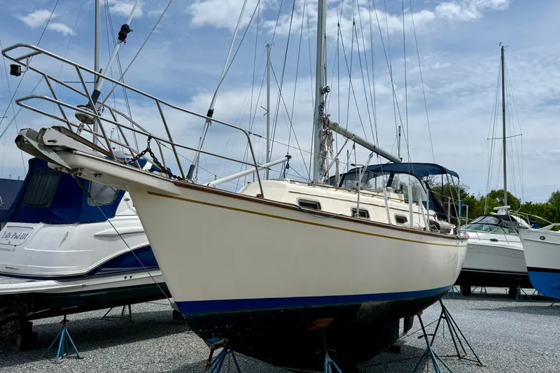 The Image of 1992 Island Packet 29 sailboat on stands, ready for maintenance under a clear sky. - 0